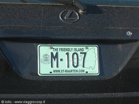 Green license plate M-107 reading The Friendly Island on a black Lexus