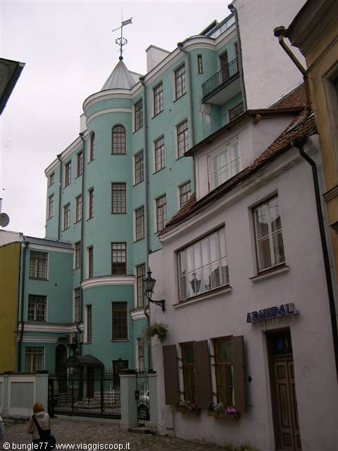 Aqua-green building with corner turret in Tallinn old town, grey sky
