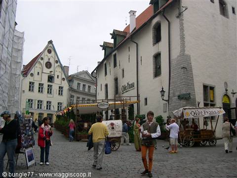 Tourists on a cobblestone square in front of the Old Hansa restaurant, Tallinn