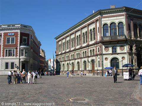 Tourists walk across the square in front of Riga's historic House of the Blackheads