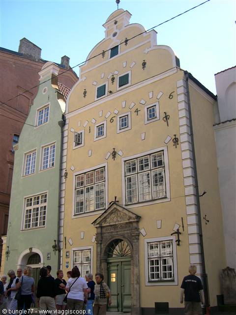 Tourists in front of the Three Brothers, yellow Renaissance facade in Riga
