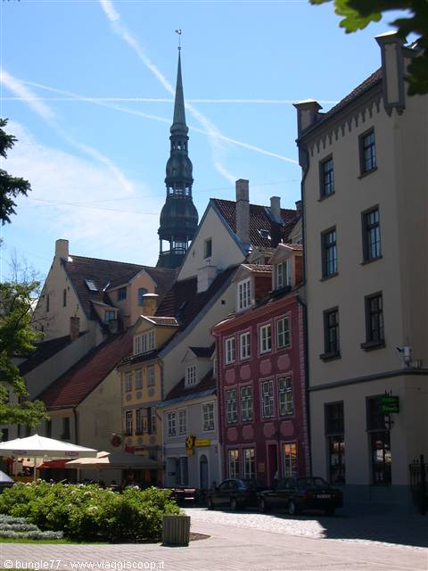 colorful houses and green church spire under blue sky in Tallinn