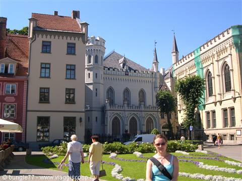 Tourists in a square garden in front of Riga's Small Guild building