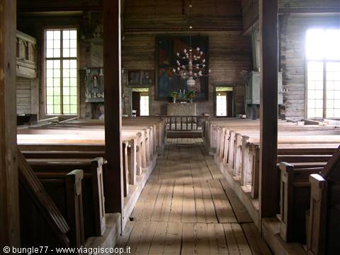 Wooden church interior, rows of pews, light through windows, chandelier
