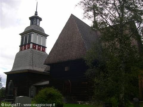 Petäjävesi old wooden church, dark log walls and bell tower under cloudy sky