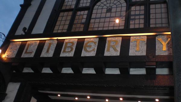 Golden Liberty sign on the dark timber facade of the London department store