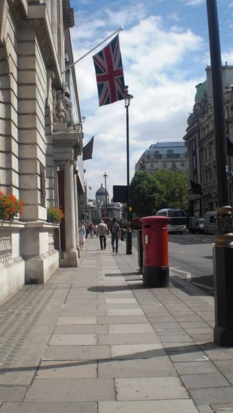 Union Jack flag and red pillar box on a London sidewalk