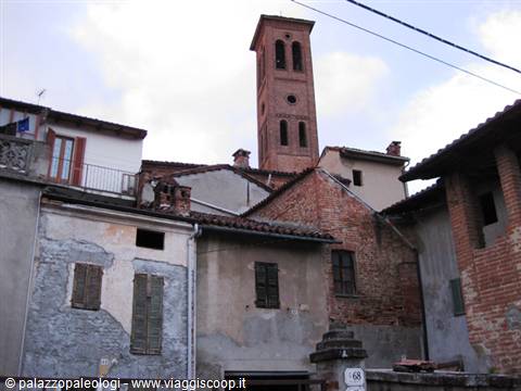 Brick bell tower rising above old weathered village houses