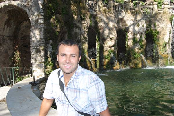 Smiling man in front of the Oval Fountain at Villa d'Este, Tivoli