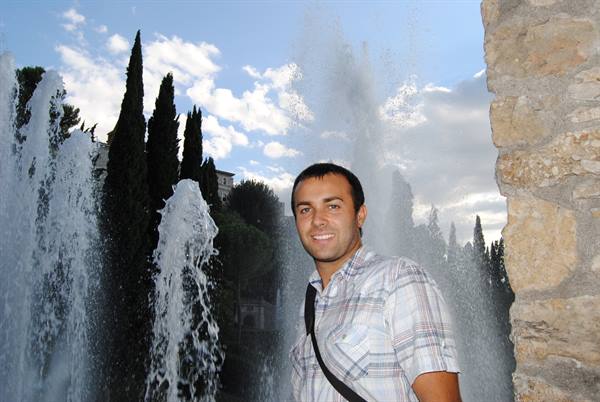 Smiling man in plaid shirt beside the fountains of Villa d'Este