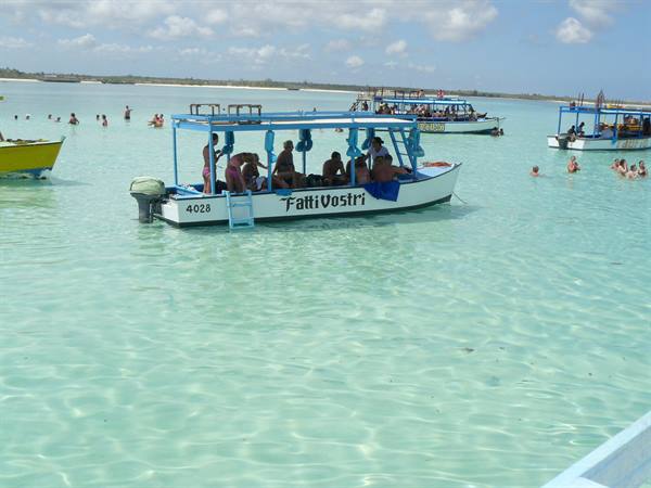 Tourists on the Fatti Vostri boat in turquoise water among other boats