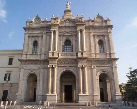Baroque facade in light stone with columns and a statue on top