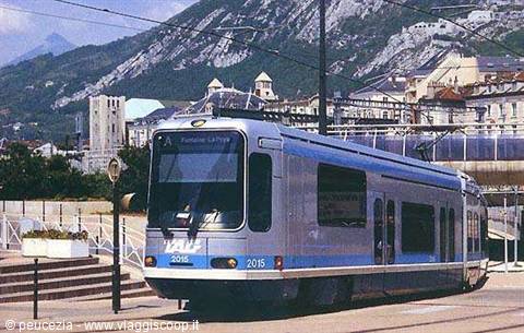 Blue and grey tram in Grenoble, with alpine mountains in the background