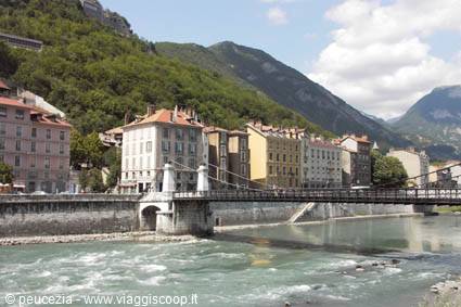 Suspension bridge over the Isère in front of Grenoble's colorful houses