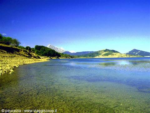 Lake Campotosto, clear greenish shallow water, Gran Sasso peaks in the distance