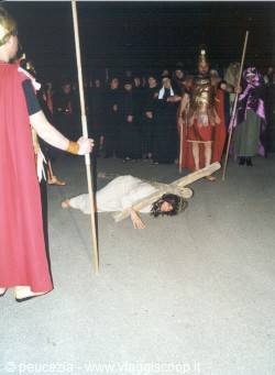 Night Via Crucis reenactment: Christ falls under the cross among Roman soldiers