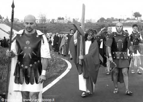 Living Stations of the Cross: men in Roman armor and Christ carrying the cross marching