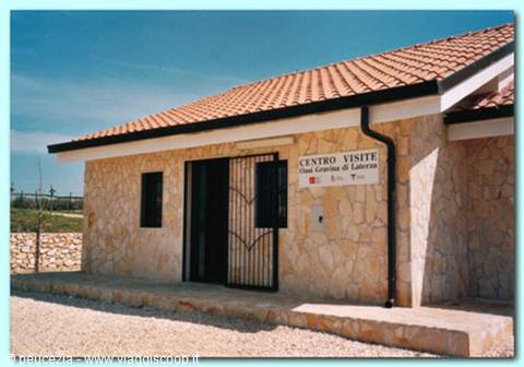 Guardaregia oasis visitor center, stone building with tiled roof under clear sky