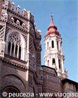 Brick bell tower and marble spire of Cremona Cathedral under blue sky