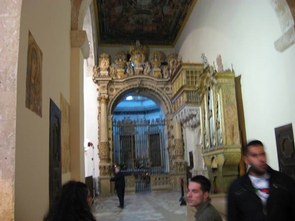 Church interior with gilded portal, carved organ and visitors in the nave
