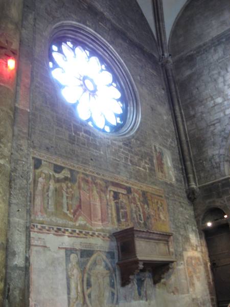 Stone rose window and medieval frescoes in San Lorenzo church, Naples