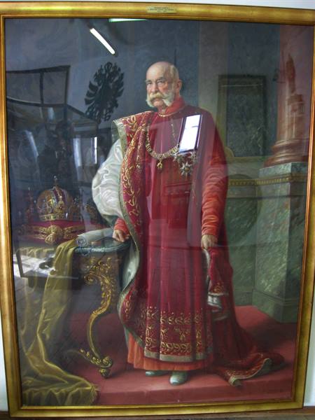 Portrait of Emperor Franz Joseph in red coronation robes, crown on gilded table