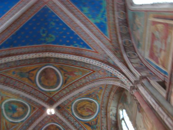 Frescoed vaults with medallions and blue starry sky inside a basilica
