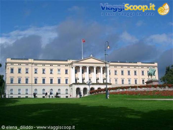 The Royal Palace in Oslo, yellow facade with columns, green lawns and pedestrians