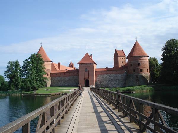Wooden bridge leading to Trakai red-brick castle on the lake island