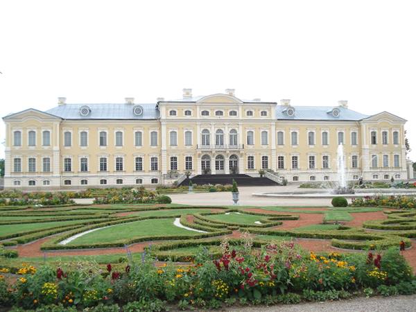 Yellow Rundāle Palace with geometric garden and fountain in front of the facade