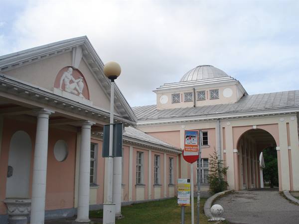 Pink neoclassical pavilion with metal dome, white columns and bas-relief in Pärnu