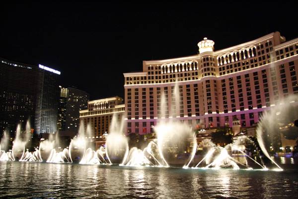 Illuminated fountains dance at night in front of the Bellagio hotel