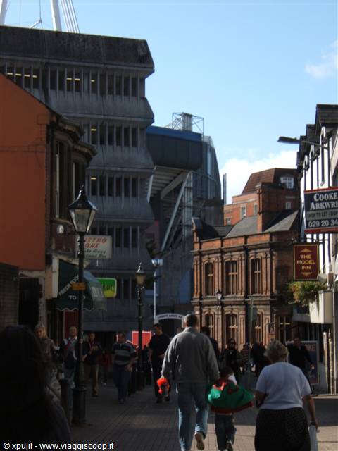 Pedestrians on a Cardiff street with the stadium in the background