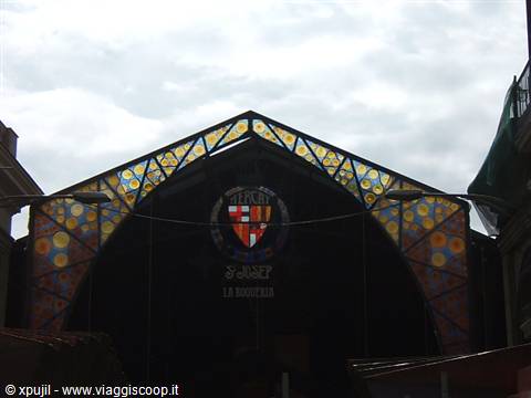 Colorful emblem facade of Sant Josep La Boqueria market under a cloudy sky