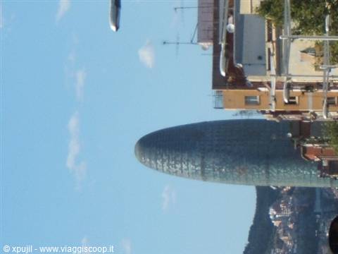 Barcelona's Torre Agbar seen sideways, blue sky and buildings