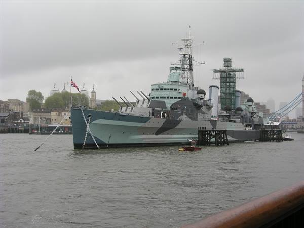 HMS Belfast cruiser moored on the Thames in London, grey sky