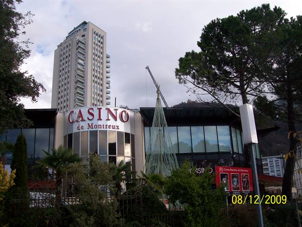 Casino de Montreux with red sign, Christmas tree and tower among pines