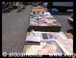 Flea market stalls displaying old books and art prints on tables
