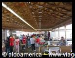 Indoor hall with wooden beamed ceiling, groups of visitors at the counter
