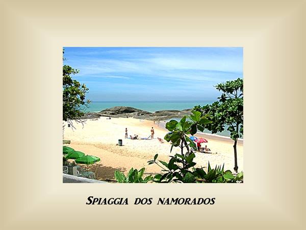 Praia dos Namorados: pale sand, rocks, green umbrellas and beachgoers