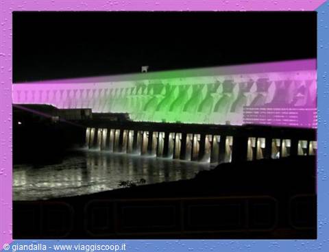 Itaipu Dam at night with green and purple light projections