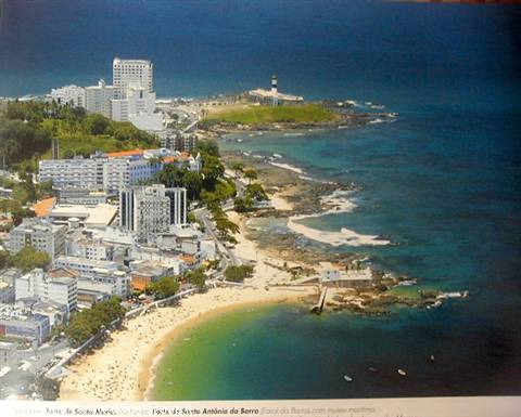 Farol da Barra lighthouse in Salvador, waves on the beach and palms