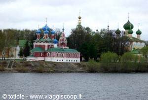 Red church with onion domes by the river in Uglich