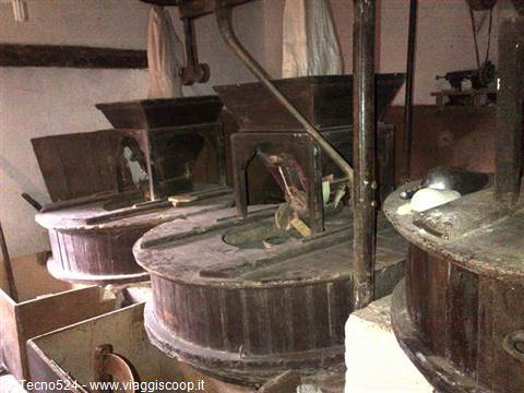 Wooden millstones of an old mill, lit by soft natural light