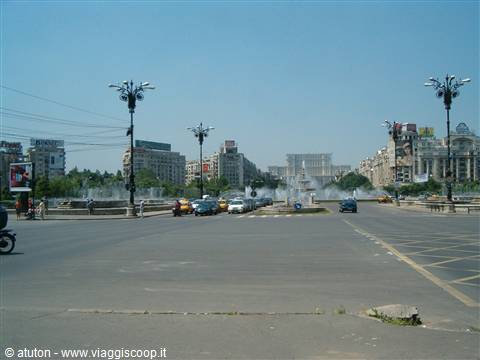 Cars among the Unirii Square fountains, Palace of Parliament behind