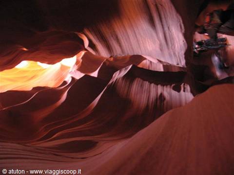 Wavy red sandstone walls in Antelope Canyon, golden light from above