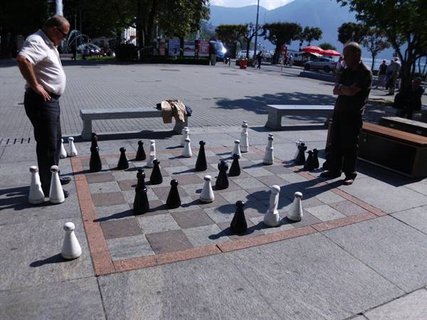 Giant stone chessboard on the lakeside square, two men playing