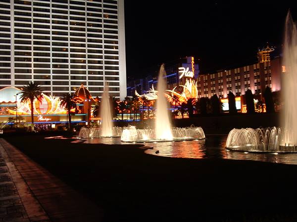 Illuminated fountains at night in front of Flamingo and Bally's hotels, Las Vegas