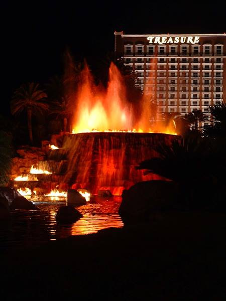 Fire eruption and falls at night, Treasure sign glowing in Las Vegas
