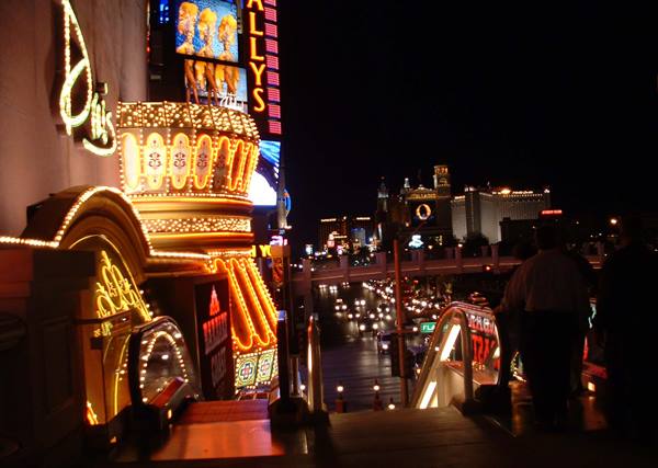 Bally's casino neon signs glow above a busy nighttime street traffic